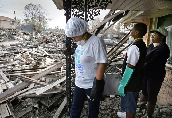 Residents look over damage to the Lower Ninth Ward from the porch of a family home in New Orleans