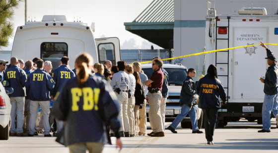 FBI investigators examine the crime scene at a parking lot and entrance of a United States Postal Service mail facility in Goleta