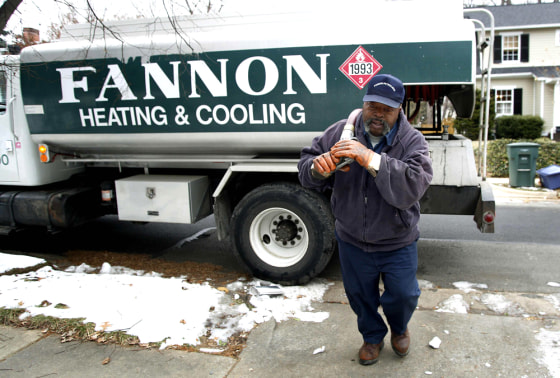 Man prepares to deliver heating oil to a house in Alexandria