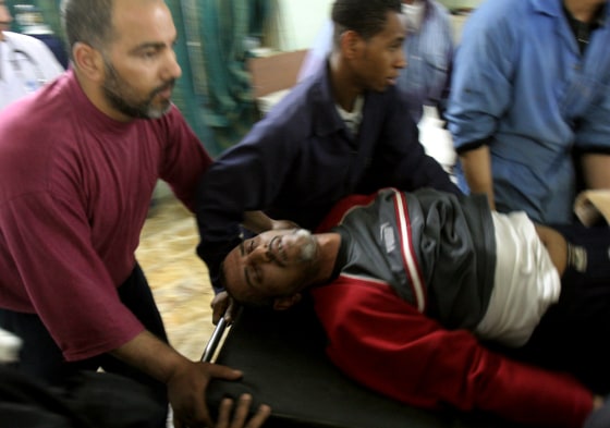 An injured Iraqi is rushed for treatment in Yarmouk hospital on Tuesday after an explosion at an outdoor market in a Shiite area of southwestern Baghdad.