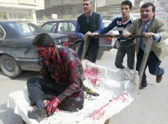 Iraqi residents push cart with wounded bomb victim in Baghdad