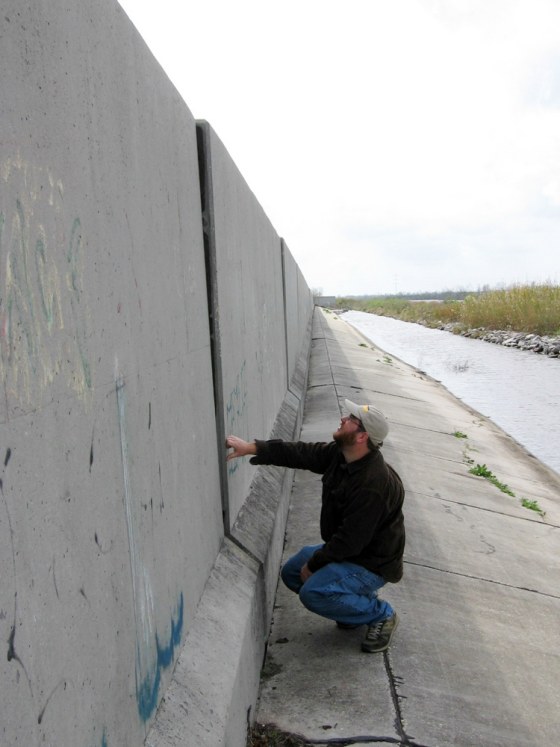 Ezra Boyd, a scientist with Louisiana State University, examines a crack in a flood wall in Jefferson Parish west of New Orleans. Scientists say many levees that survived Hurricane Katrina suffered significant structural damage but are not scheduled for repair.