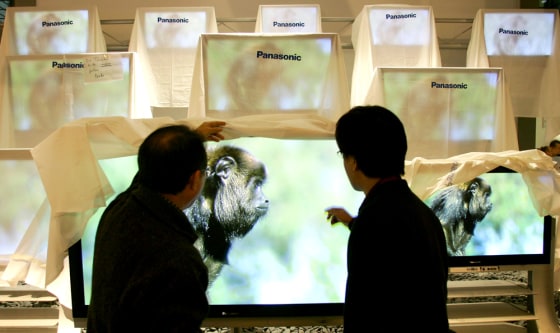 Technicians check flat screens on the booth of Panasonic at the CeBIT computer fair in Hanover
