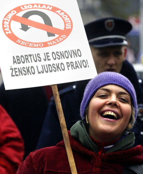 A woman holds a banner reading "Abortion is a basic women's right!" and "No turning back — abortion is legal" at a rally in Belgrade, Serbia, on Tuesday.