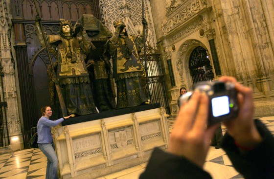 Tourists pose at the tomb of Christopher