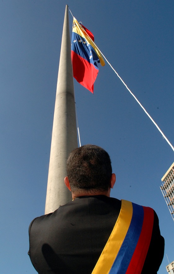 Venezuelan President Hugo Chavez raises his country's new flag at a Sunday ceremony at the National Pantheon in Caracas, Venezuela. The flag has garnered reaction, not all of it favorable.