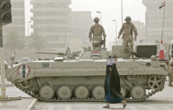 An Iraqi woman crosses a street in front