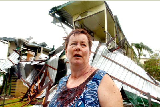 Covered in blood, Kate Charleston stands outside her home in Innisfail, Australia, from which she narrowly escaped on Monday. State and federal governments declared a state of emergency within hours.