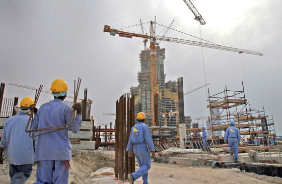Some of the 2,500 workers on the emerging Burj Dubai tower and surrounding housing developments, background, mill in the shadows of the gray concrete tower, now 36 stories tall, in Dubai, United Arab Emirates, on Wednesday.