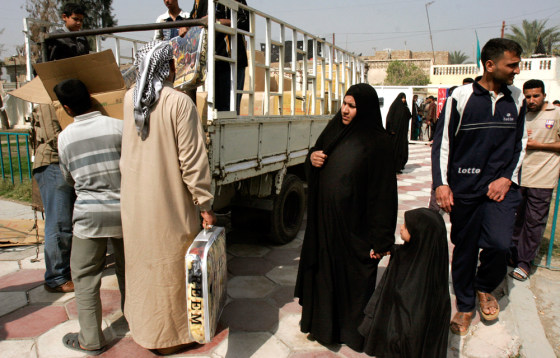 An Iraqi woman and her child wait to receive aid in a makeshift refugee camp in Baghdad on March 1. Thousands of Sunni and Shiite Muslim families have been forced to leave their homes after an outbreak of sectarian killings sparked by the Feb. 22 bombing of the Shiite holy shrine in Samarra.