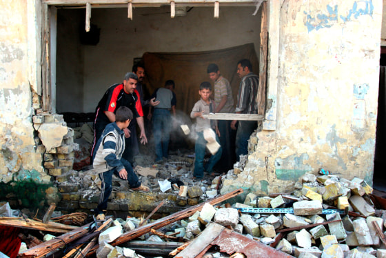 Iraqi men sweep up debris of their damaged house on Sunday after some of the violence that punctuated the weekend in Baghdad.