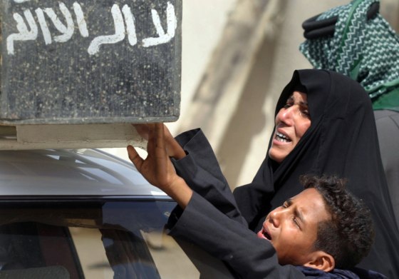 Woman and boy reach out to touch coffin of youth killed by blast in southern Iraqi city of Basra