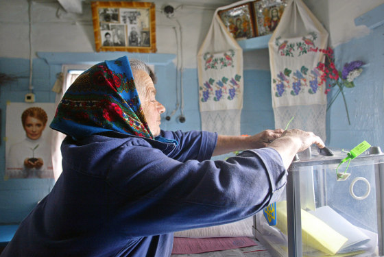 A woman casts her ballot at her home in