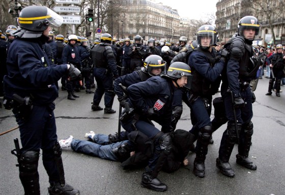 French riot police apprehend a youth during clashes at end of protest in Paris