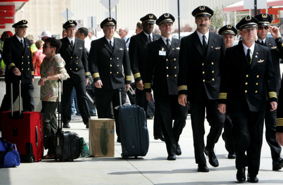 Delta pilots walk past a baggage check area ouside Hartsfield-Jackson International Airport in Atlanta on Thursday. About 275 Delta pilots marched through the Atlanta airport to protest proposed concessions.