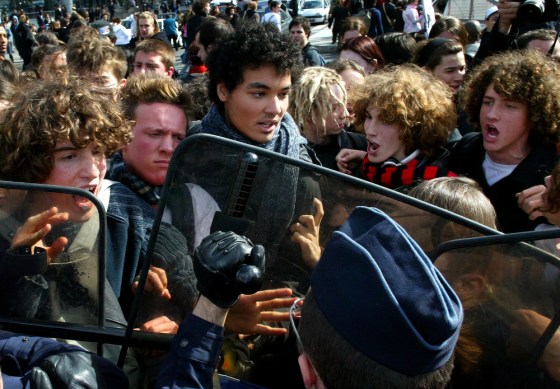 French police hold students back during a protest against the youth job law in Paris