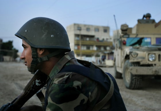An Iraqi commando patrols Baghdad, Iraq, with U.S. troops on Wednesday. American troops train Iraqi forces while monitoring them to make sure they don't join violent Shiite groups.