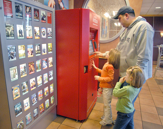 Chris Kliner and his daughters Olivia, 5, right, and Annaliese, 4, select a rental DVD from a Redbox before heading in to eat at McDonald's in Apple Valley, Minn. The fast-food giant is hoping the convenience of renting DVDs at its restaurants will turn into handsome profits.