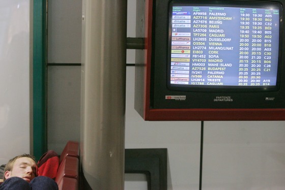 A passenger sleeps near an information b