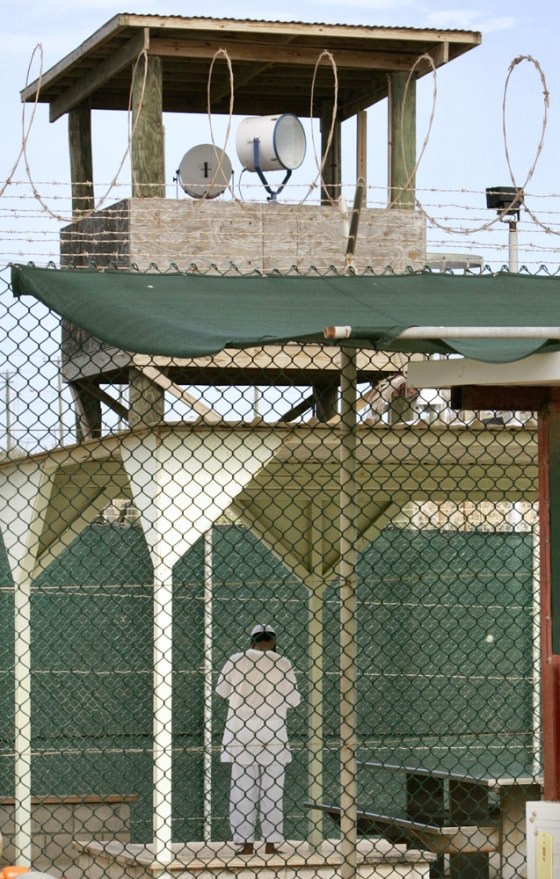 An unidentifiable detainee spends time outside his cell in the Guantanamo Bay Naval Station, Cuba, on July 6, 2005.