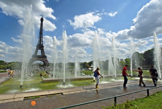 Residents and tourists refresh in the Trocadero fountains in July in Paris.