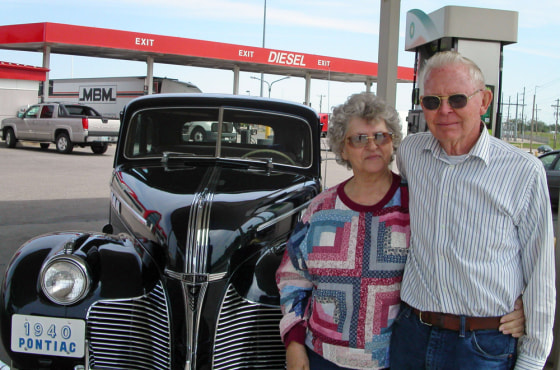 Carl and Frances Barrier stand beside their 1940 Pontiac at a service station in Salina, Kan. on May 12, en route to a car club meeting in Minden, Neb. Their car gets about 10 miles per gallon, they said, but high gasoline prices have not lessened their enthusiasm for the antigue vehicle.