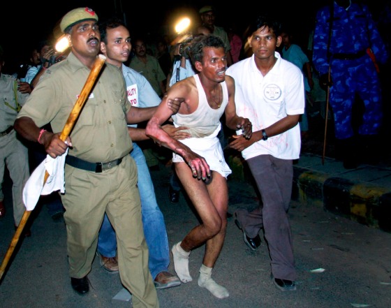 An Indian medical student who tried to immolate himself is taken to the hospital by police personnel during a rally in New Delhi