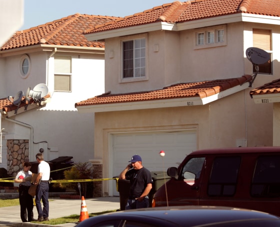 Garden Grove, Calif. police stand outside a home Wednesday where officers found three dead people and an unharmed baby girl. Police had no suspects in the deaths. 