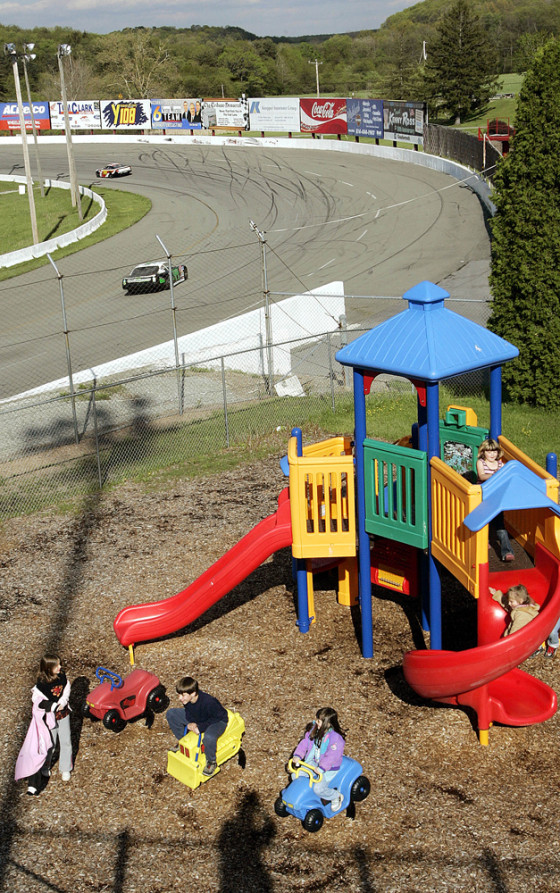While cars run practice laps at the Jennerstown Speedway, children play at the track's new playground. Smaller racetracks are increasingly trying to make their facilities more family-friendly.