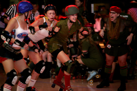 Meghan Kapousouz, aka Meg MyDay, takes on two skaters from the Honky Tonk Heartbreakers as Alyssa Hoppe (Captain Lorna Boom), right, shouts encouragement in Austin, Texas.