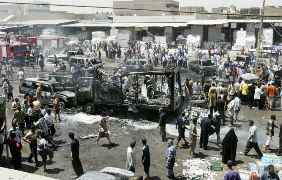 Residents gather at the scene of a car bomb attack in a crowded market in Baghdad