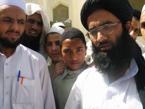 Religious students in Peshawar, Pakistan surround teacher Wahidullah, right, who once fought as part of the Taliban militia and now believes they should return to quash immorality and lawlessness.