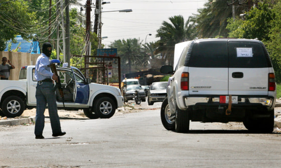An Iraqi policeman patrols near a Russian diplomatic vehicle which was attacked in Baghdad earlier this month, resulting in a Russian diplomat being killed and four diplomatic employees being kidnapped.