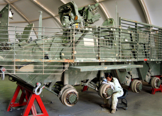 A military contractor inspects a U.S. Army Stryker transport vehicle at Camp Anaconda in Balad, Iraq, on Saturday.
