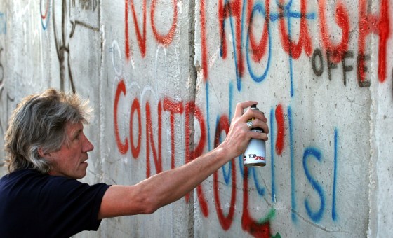 British rock musician and Pink Floyd co-founder Roger Waters spray-paints the words "No Thought Control" on a section of Israel's separation barrier in the West Bank Wednesday. Waters wrote slogans on the wall in protest against the construction of the barrier, which Palestinians say is a land grab and Israel says is necessary for its security.