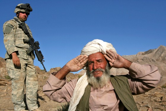 An Afghan villager holds his hands up to show he has no weapons before being searched by U.S. Army Staff Sgt. Mathew Banaszewski at Helmand Province, Afghanistan, on Wednesday.