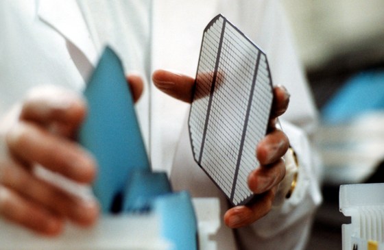 A worker at BP Solar’s plant near Madrid, Spain, assembles a silicon wafer.