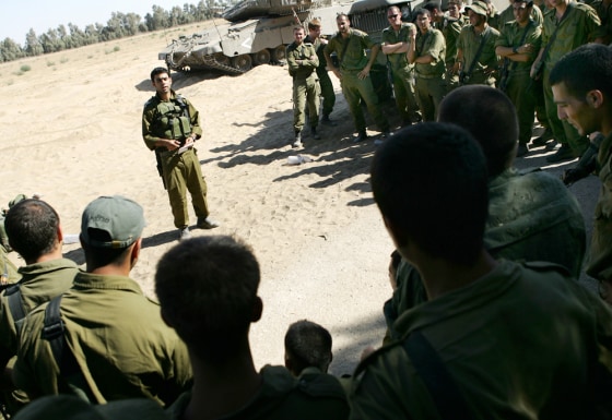 Israeli soldiers listen to their commander's briefing on Sunday before the drive towards the abandoned airport near the town of Rafah in the southern Gaza Strip. 