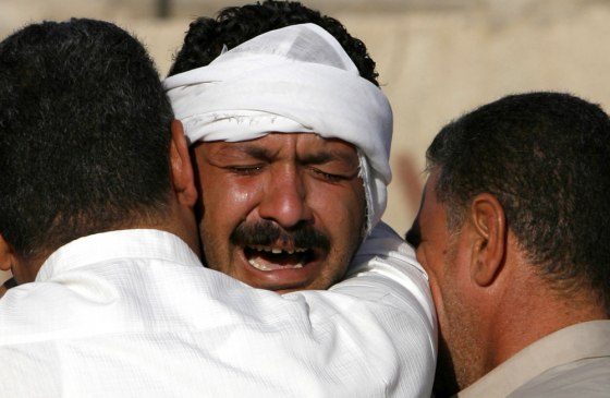 Man cries outside Yarmouk hospital morgue after his brother was killed by gunmen in Doura district in Baghdad