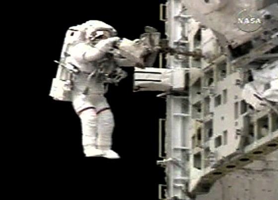 Spacewalker Sellers puts away tools on the tool pallet in the Shuttle Discovery's payload bay near the end of the EVA