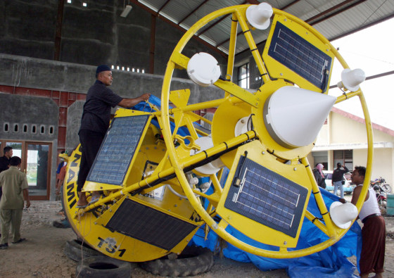A man checks a tsunami buoy, brouoght back from sea after it was damaged, at a warehouse in the West Sumatra city of Padang, in this May 8, 2006 file photo