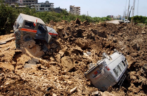 A Lebanese military jeep, left, and a civilian van were destroyed in an Israeli warplane missile attack in the southern port town of Tyre, Lebanon, on Wednesday.