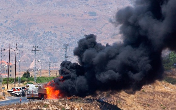 Black smoke rises from a truck set ablaze after Israeli airstrikes in the city of Zahle, in Lebanon's Bekaa Valley, on Tuesday. After the strike, paramedics tried to rescue people from their cars on the side of the road.