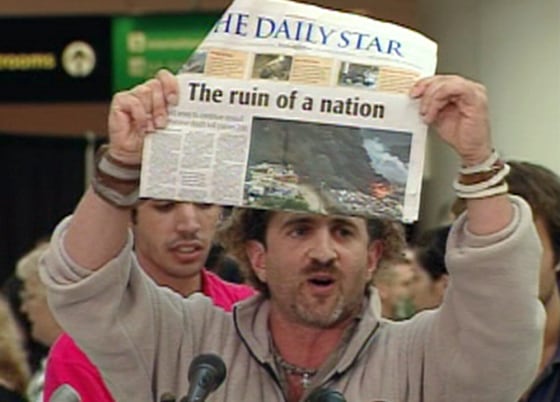 David Merhige, one evacuee from Lebanon, holds up a newspaper to make a point about destruction in the nation as he arrives in Baltimore Thursday.