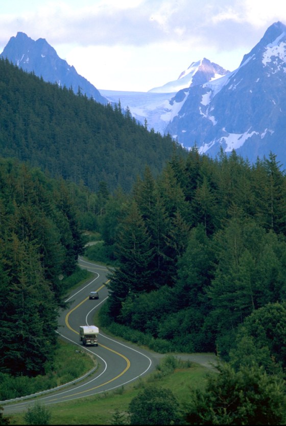 Vehicles wind down the mountains from Eureka Summit on Alaska's Glenn Highway. The road affords incredible vistas, including nearby Matanuska Glacier.