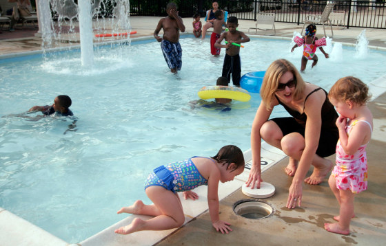 Abby Hopper and her daughters Madeline, 3, and Elli, 2, play at the Sycamore Club Pool on July 11 in Bowie, Md. On this particular afternoon, they were the only Caucasians at the pool.