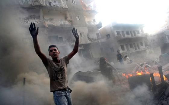 A man yells for a fire hose after a building in the Lebanese city of Tyre was hit by Israeli warplanes on Wednesday.