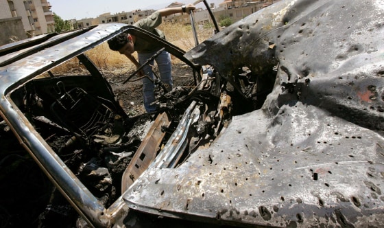A Lebanese looks at the damage to a car hit by an Israeli air strike in al-Bekaa