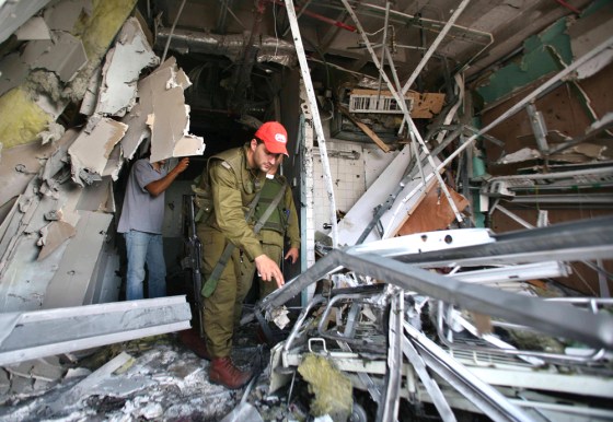 An Israeli policeman surveys a damaged floor at a local clinic in Nahariya