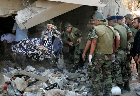 A Lebanese soldier throws a baby stroller Sunday as he and others search for bodies under the rubble of a home hit in an Israeli missile strike in the village of Qana, east of the port city of Tyre.